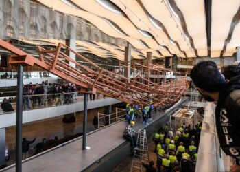 PENGUNJUNG melihat pekerja muzium memasang papan kayu purba daripada perahu kedua Raja Khufu ke atas struktur logam di Muzium Besar Mesir di Giza, pinggir Kaherah.-AFP