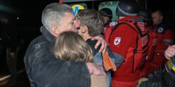 SEORANG lelaki memeluk anak-anaknya di lokasi serangan dron Russia di Kharkiv pada 23 November lalu, ketika pencerobohan Russia ke atas Ukraine.- AFP