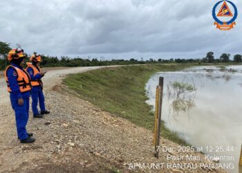 ANGGOTA APM Kelantan melakukan pemantauan paras air banjir di Rantau Panjang, Kelantan.