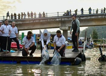 TUANKU Syed Faizuddin Putra Jamalullail (dua dari kanan) berkenan membuat gimik pelepasan ikan bersempena dengan Program Berkayak anjuran TNB Perlis dengan kerjasama Jabatan Pengairan dan Saliran (JPS) negeri di Kampung Wai, Kuala Perlis, Perlis. -UTUSAN