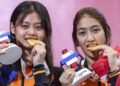 Atlet terjun, Nurul Farisya Alia Affendi (kiri) dan Nur Eilisha Rania Muhammad Abrar menunjukkan pingat emas yang dimenangi dalam acara 10 meter (m) platform seirama wanita Sukan SEA Thailand. - UTUSAN/FARIZ RUSADIO