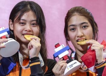 Atlet terjun, Nurul Farisya Alia Affendi (kiri) dan Nur Eilisha Rania Muhammad Abrar menunjukkan pingat emas yang dimenangi dalam acara 10 meter (m) platform seirama wanita Sukan SEA Thailand. - UTUSAN/FARIZ RUSADIO