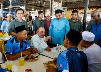 ANWAR Ibrahim meluangkan masa beramah mesra dengan orang ramai ketika makan tengah hari di D’Jit Seafood, pekan Kuah, Pulau Langkawi, Kedah, semalam. - UTUSAN/SHAHIR NOORDIN