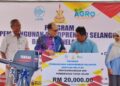IZHAM Hashim (dua, kiri) menyerahkan bantuan kepada wakil persatuan nelayan kawasan pada Program Pembangunan Agropreneur Selangor Bantuan Nelayan, dekat Tanjong Karang, di Kuala Selangor, Selangor, semalam.