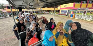 Para guru ceria dan gembira ketika menaiki traktor pengangkut (tram) ke Sekolah Kebangsaan Pusat Penyelidikan Pertanian Tun Razak, Tekam di Jerantut, Pahang.