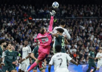 Penjaga gol Manchester City, Gianluigi Donnarumma mengeluarkan bola dari kawasan bahaya dalam serangan pantas Real Madrid pada saingan Liga Juara-Juara di Stadium Santiago Bernabeu, Madrid, semalam. - AFP