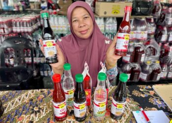 Nor Arizah Nayan menunjukkan produk sos cili jenama Doon keluaran syarikatnya Shaidon Awang Empire Sdn. Bhd.