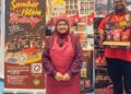 ROHANA Mohd Isa (depan) dan Mohd Farhan Azuan Mohd Azlan bersama reruai pameran produknya, Cikgu Ana.