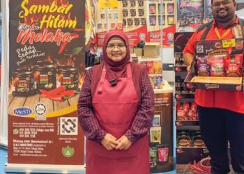 ROHANA Mohd Isa (depan) dan Mohd Farhan Azuan Mohd Azlan bersama reruai pameran produknya, Cikgu Ana.