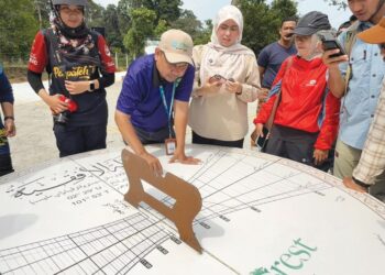 MUZAMIR Mazlan (tengah) melakukan demonstrasi penggunaan jam matahari gergasi bagi menentukan arah kiblat dan waktu solat. – UTUSAN/NOR SHAFIQAH MOHD.GHAZALI