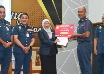 SELAKU juara, Mohd. Lokman menerima hadiah serta sijil Program Intervensi Pengurusan Berat Badan sempena Perhimpunan Bulanan Disember 2025 Jabatan Bomba dan Penyelamat Malaysia (JBPM) Melaka, di Bukit Katil, hari ini. - UTUSAN/AMRAN ALI.