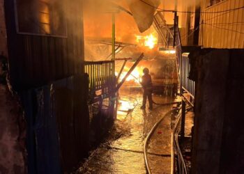 Pasukan bomba bertindak memadam kebakaran dengan menggunakan bekalan air daripada tangki simpanan jentera bomba sebelum disambung dengan sumber air terbuka iaitu air laut. GAMBAR/ IHSAN JBPM SABAH