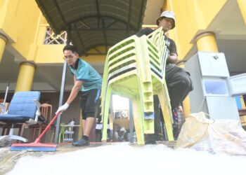 MAJLIS Perwakilan Pelajar (MPP) Universiti Malaysia Pahang Al-Sultan Abdullah (UMPSA), P. Arvind, 22 (kiri), bersama menyertai kerja amal gotong-royong membersihkan sebahagian kawasan di UnIPSAS yang ditenggelami banjir pada 18 Disember lalu. - FOTO/SHAIKH AHMAD RAZIF