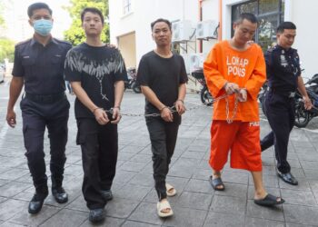 TIGA lelaki warga China diiringi oleh dua anggota polis (kiri dan kanan) ketika dibawa ke Mahkamah Majistret George Town, Pulau Pinang atas pertuduhan mengedar dadah berbahaya jenis methamphetamine pada 20 Disember lalu. - UTUSAN/DANIAL SAAD