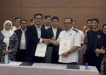 ZUHAIRI Ab. Kadir (depan, kanan) bersalaman dengan Mohd. Rizal Abdul Rahim selepas menandatangani perjanjian kerjasama strategik di sebuah hotel di Kuantan, Pahang.