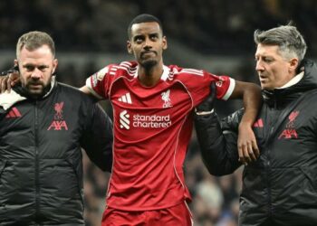 Penyerang Liverpool, Alexander Isak dipapah dua pegawai perubatan kelab itu selepas mengalami kecederaan ketika beraksi menentang Tottenham Hotspur di Stadium London, 20 Disember lalu. - AFP