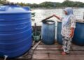 Masalah bekalan air yang dihadapi oleh penduduk Pulau Gaya, Kota Kinabalu Sabah Kamsiah Maulaha, 60, yang terpaksa membeli bekalan air setiap hari dengan harga RM10 untuk satu tong dram air ketika tinjauan di Kota Kinabalu. – MINGGUAN/AMIR KHALID