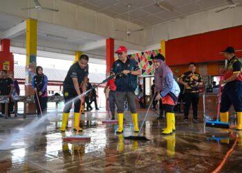 KAMSAH@KAMAL Mohamed (tengah) bersama guru membersihkan kawasan sekolah yang terjejas banjir pada Program Pembersihan Sekolah Pasca Banjir di Sekolah Kebangsaan Kedai Buloh, Kuala Terengganu, Terengganu. - UTUSAN/PUQTRA HAIRRY