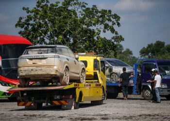 BEBERAPA trak tunda membawa sebahagian kenderaan milik rakyat Malaysia yang ditenggelami air akibat bencana banjir besar Hat Yai di Bukit Kayu Hitam, Kedah.-UTUSAN/SHAHIR NOORDIN.