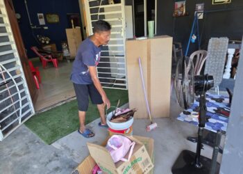 PENDUDUK membersihkan rumah mereka daripada kotoran akibat banjir ketika tinjauan di Teluk Intan, Perak semalam. – UTUSAN/AIN SAFRE BIDIN