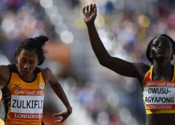 Zaidatul Husniah Zulkifli (kiri) ketika bersaing dengan pelari Ghana, Owusu Agyapon dalam saringan 100 meter Sukan Komanwel Gold Coast 2018. - AFP
