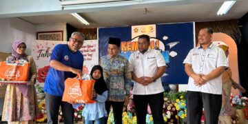 AZRAN Fitri Rahim (dua dari kiri) diiringi Hasli Hussin (dua dari kanan) menyampaikan set kelengkapan ‘Kembali Ke Sekolah-Pemasik’ kepada seorang murid di Sekolah Kebangsaan Seri Dusun, Sik, baru-baru ini.