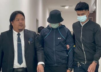 TERTUDUH (tengah) dibawa keluar dari mahkamah selepas berdepan tuduhan menyalahgunakan jawatan bagi mendapatkan suapan buat isteri di Mahkamah Seksyen Kangar, Perlis hari ini. -UTUSAN/ASYRAF MUHAMMAD