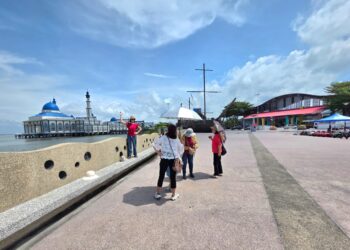 KUMPULAN pelancong dari China bergambar dengan latar belakang Masjid Tuminah Hamidi di Bagan Datuk, Perak. – UTUSAN/AIN SAFRE BIDIN
