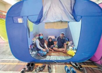 ROZITA Shaari dan suami, Mat Rashid Muhammad Nawawi bersama anak mereka yang ditempatkan di PPS IPD Hilir Perak di Teluk Intan semalam. – UTUSAN/AIN SAFRE BIDIN