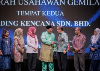 MUSTAFFA Kamal Ayub (tiga dari kanan) menyampaikan Anugerah Usahawan Gemilang Tempat Kedua kepada Muhamad Guntor Mansor Tobeng (empat dari kiri) pada AUMI25 di Cyberjaya baru-baru ini. - UTUSAN/FAIZ ALIF ZUBIR