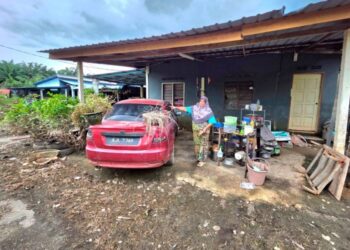 HALIJAH Ahmad menunjukkan keadaan rumahnya selepas banjir surut 
di Kampung Batu Tujuh, Changkat Jong di Teluk Intan, semalam. 
– UTUSAN/AIN SAFRE BIDIN