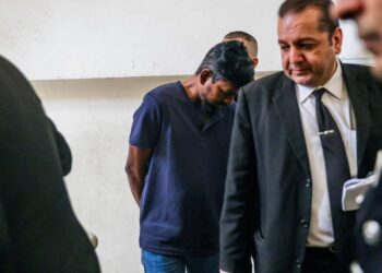 HANARAJ Sugumaran (tengah) ketika ditemui di pekarangan Mahkamah Majistret di sini hari ini atas pertuduhan memiliki bahan lucah dalam telefon pintar. - UTUSAN/ZAHRA MOHAMAD ZHAHIR