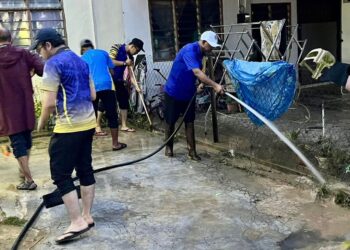 AFFENDI Rajini Kanth bersama kakitangan MPK membersihkan rumah mangsa banjir di Taman Bukit Kayangan, Kangar, Perlis semalam.-UTUSAN