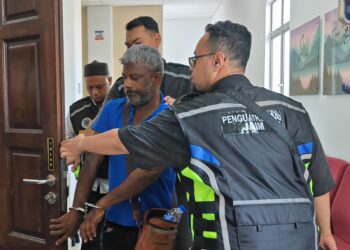 IBRAHIM Bacha diiringi anggota penguat kuasa Jabatan Agama Islam Melaka (JAIM) ketika dihadapkan ke Mahkamah Tinggi Syariah, Ayer Keroh, Melaka. - UTUSAN/AMRAN ALI