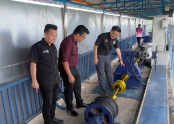 LIM Ban Hong (kanan) melihat pintu air yang sudah dibaiki sewaktu meninjau Pintu Kawalan Air Pasang Surut di Klebang Besar, Melaka. - UTUSAN/AMRAN MULUP