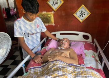 MOHAMMAD Syafik Azhar menjaga bapanya yang koma  di Kampung Parit Tengah, Pekan, Pahang.