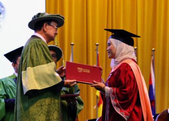 Afrina Syahirah Kaharudin (kanan) menerima skrol graduasi daripada Pro Canselor UPM, Peter Chin Fah Kui dalam Majlis Konvokesyen UPM ke-49, semalam.