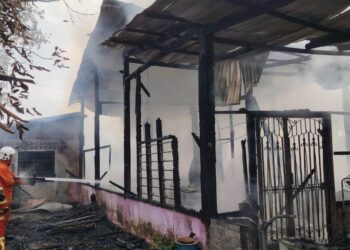 DUA anggota bomba bertungkus-lumus memadam kebakaran yang berlaku di sebuah rumah di Kampung Permatang Tok Gelam, Kepala Batas, Pulau Pinang pagi tadi.-GAMBAR/JBPM PULAU PINANG