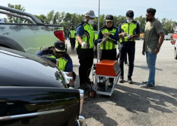 PENGUATKUASA JAS ketika memeriksa salah satu kenderaan ketika Operas Gerak Kenderaan Bermotor di Plaza Tol Nilai di Seremban hari ini.-UTUSAN / NOR SHAFIQAH MOHD GHAZALI