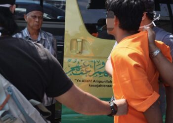 SUSPEK yang didakwa membunuh isterinya sempat meminta maaf kepada bapa mentuanya, Ishak Man (kiri) ketika dibawa keluar dari di Unit Forensik Hospital Seberang Jaya (HSJ), Pulau Pinang hari ini.-UTUSAN/DANIAL SAAD