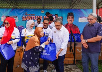 JOHARI Abdul Ghani menyampaikan sumbangan pada Program Santuni Madani Kementerian Perladangan dan Komoditi di Perumahan Awam Sri Perlis 2, Kuala Lumpur hari ini. - UTUSAN/ISKANDAR ISHAK