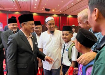 Mohd. Na’im Mokhtar beramah mesra dengan salah seorang penerima Bantuan Persekolahan MAIWP 2026 di Masjid Wilayah Persekutuan, di sini, pagi tadi.