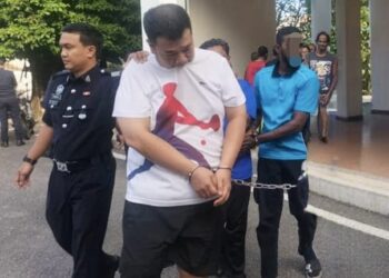 OOI Teik Kuan (tengah) ketika dibawa ke Kompleks Mahkamah Pulau Pinang di George Town, Pulau Pinang hari ini atas pertuduhan melakukan ugutan jenayah terhadap seorang individu, Februari lalu.-UTUSAN/SAFINA RAMLI