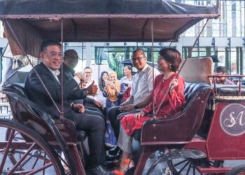 WONG Hon Wai (kiri) dan Haryany Mohamad (kanan) mencuba salah satu pedati atau kereta kuda yang dipamerkan sempena majlis penyerahan projek cadangan pembinaan ruang kereta kuda dan kereta-kereta antik di Jalan Macalister, George Town, Pulau Pinang, hari ini.-UTUSAN/DANIAL SAAD