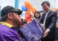 CHOW Kon Yeow (kanan) menyerahkan sumbangan kepada seorang pelajar istimewa dari Pusat Pemulihan Dalam Komuniti (PPDK) pada Majlis Pelancaran Kalendar Kita Bersama Petron Pulau Pinang dan JKM Pulau Pinang 2025 di George Town, Pulau Pinang hari ini.-UTUSAN/DANIAL SAAD