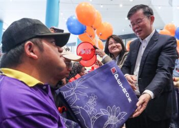 CHOW Kon Yeow (kanan) menyerahkan sumbangan kepada seorang pelajar istimewa dari Pusat Pemulihan Dalam Komuniti (PPDK) pada Majlis Pelancaran Kalendar Kita Bersama Petron Pulau Pinang dan JKM Pulau Pinang 2025 di George Town, Pulau Pinang hari ini.-UTUSAN/DANIAL SAAD