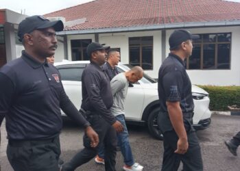 ZAINIZAN Zainal diiringi anggota polis dibawa keluar dari Mahkamah Majistret Tampin selepas menghadapi pertuduhan membunuh Suri Narudin hari ini. -UTUSAN / NOR SHAFIQAH MOHD GHAZALI.