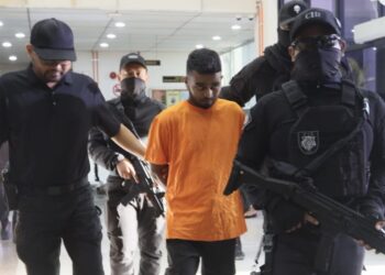 AUNG Soe (tengah) diiringi oleh beberapa anggota polis ketika tiba di Mahkamah Sesyen Butterworth, Pulau Pinang hari ini atas pertuduhan memiliki sepucuk pistol tanpa permit.-UTUSAN/DANIAL SAAD