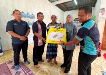 BADRUL Hisham Alias (dua dari kiri) menyampaikan Sumbangan Tabung Segenggam Beras JPN Kelantan kepada Mohd. Noor Mohd. Zain di rumahnya di Kampung Gong Tungai, Gunong, Bachok, Kelantan.