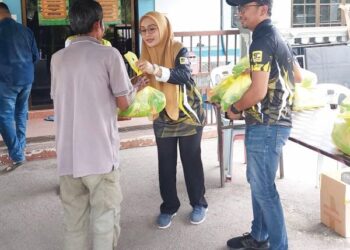 Norhaslinda Zakaria menyampaikan sumbangan beras kepada penduduk DUN Pangkor. – MINGGUAN/AIN SAFRE BIDIN